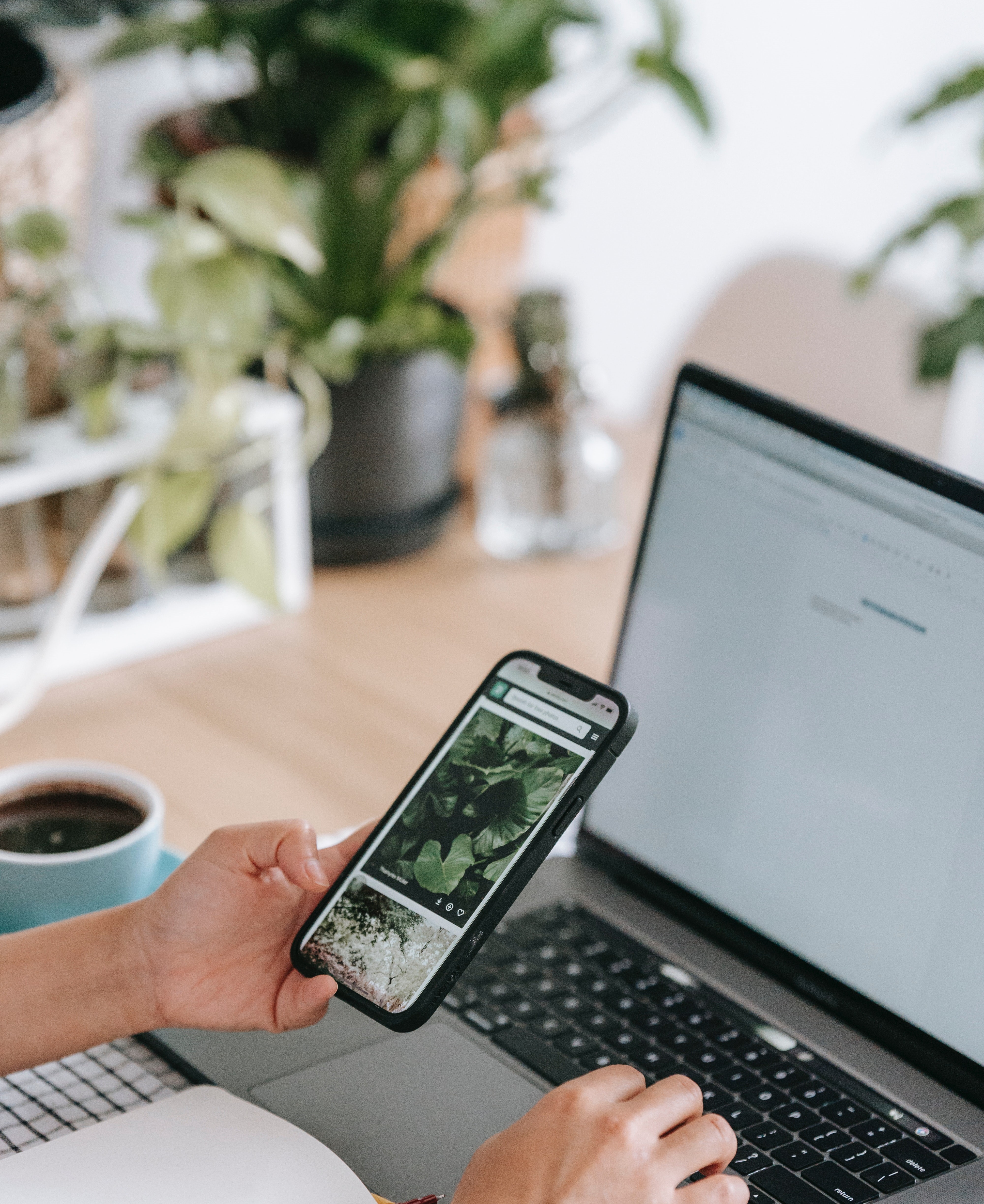 personne sur un bureau avec un ordinateur portable et utilisant son téléphone portable personne sur un bureau avec un ordinateur portable et utilisant son téléphone portable